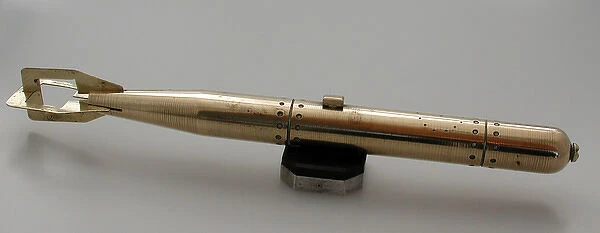 Brass model of torpedo sitting on bakelite and metal stand