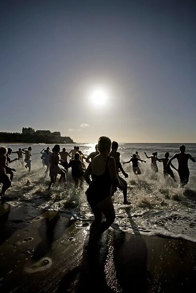 People running into the sea