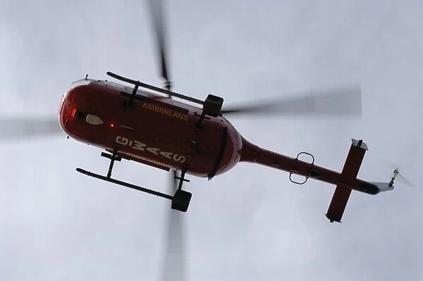 Wales Air Ambulance helicopter in flight after rescuing a casualty at Solva harbour, Solva, Pembrokeshire, Wales, UK