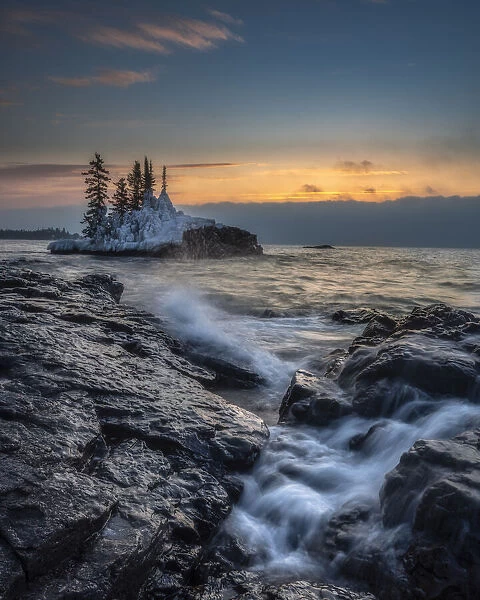USA, Minnesota, Lake Superior. Lake waves and rocks at sunrise