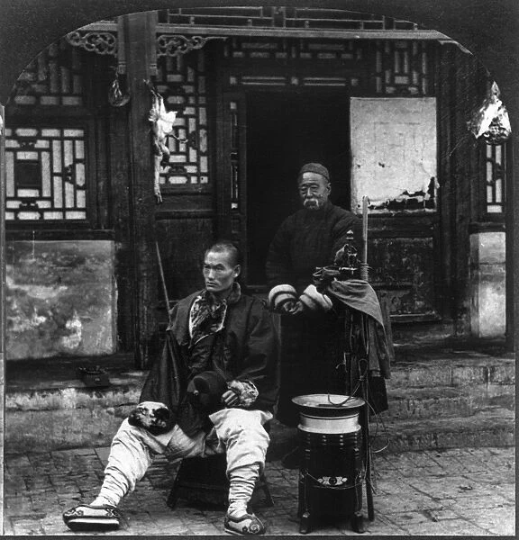CHINA: STREET BARBER, c1919. Chinese barber and customer on the sidewalk, Peking, China