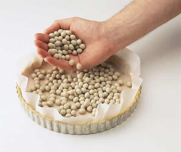 Filling pastry tray with dried beans before cooking