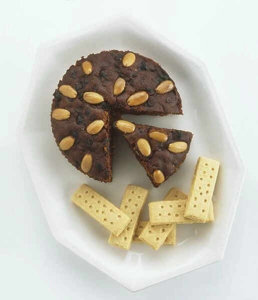 Shortbread biscuits and Dundee cake made from dried fruit and spices and topped with almonds, view from above