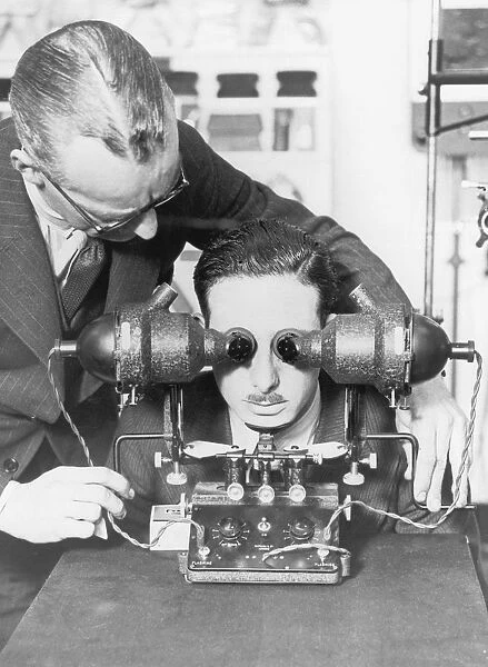 Optician. An optician performs an eye test on a patient, circa 1930