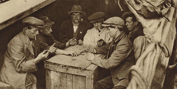 Bargee and his mates playing dominoes in the hold of a barge on a London canal (b  /  w photo)