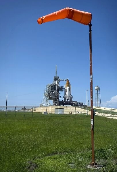 Space shuttle Endeavour is framed by a windsock at the launch pad at Kennedy Space Center