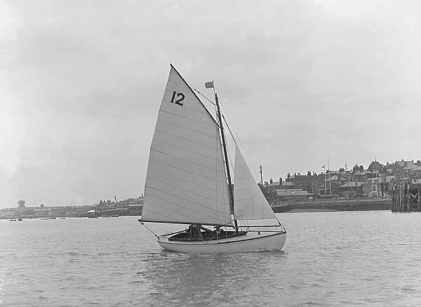 A Hamble River Class dinghy (No 12) sailing close-hauled, 1921. Creator: Kirk & Sons of Cowes