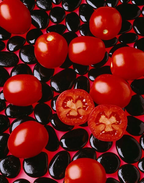 Agriculture - Processing tomatoes on black rocks and red surface, sliced, studio
