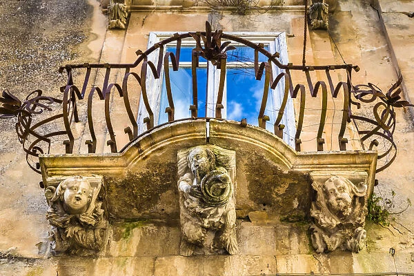 Baroque balcony railing with carved stone supports in Ragusa in Sicily, Italy