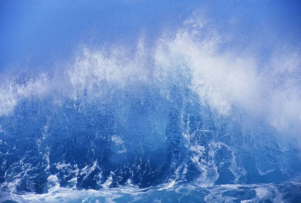 Blue Waves Crashing On The Shore With Blue Sky Background