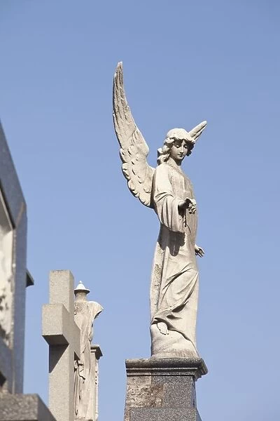 Buenos Aires, Argentina; Angel Statues And A Cross Made Of Stone On Top Of Tombs In The Recoleta Cemetery