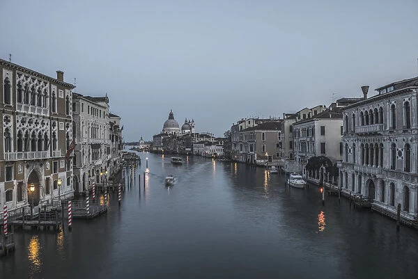 A Canal At Dusk With The Salute Church In The Distance; Venice, Veneto, Italy