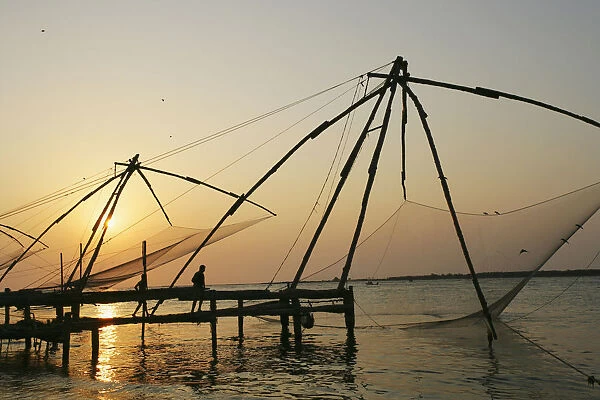 Chinese Fishing Nets Hanging In The Water At Sunset, Fort Kochi