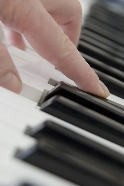 Close Up Of Finger Playing Piano Keyboard