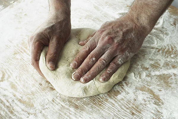 Close-Up Of Hands Kneading Dough