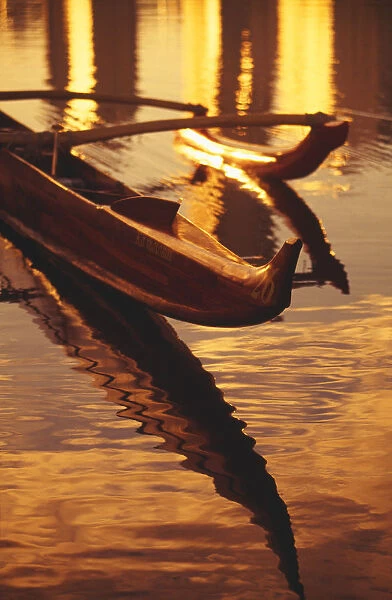 Closeup Of Koa Outrigger Canoe On Water With Reflection Of Golden Sunset