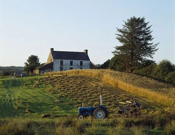 County Cork, Ireland; Farmer On Tractor Harvesting Field