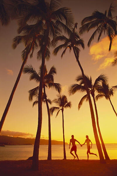 Couple Runs Together Holding Hands, Golden Sunset, Palm Trees, Ocean In Background