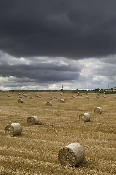 Dark Storm Clouds Over A Field With Hay Bales; South Shields, England