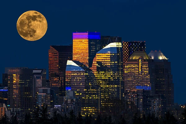 Dramatic harvest moon over city skyline