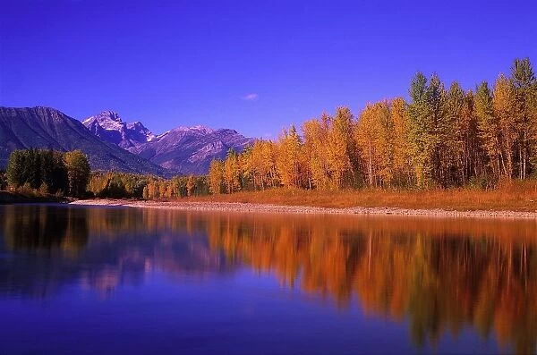 Elk River In Autumn With Three Sisters Mountain Range In The Background; Fernie, British Columbia, Canada