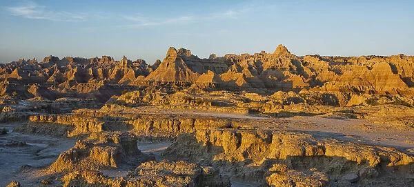 The eroded formations of badlands national park light up at sunrise from the window and door trail; south dakota united states of america