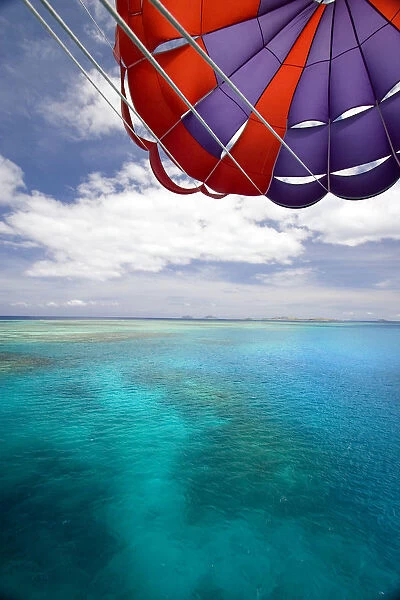 Fiji, Colorful parachute over reef and Pacific Ocean; Mamanuca Islands