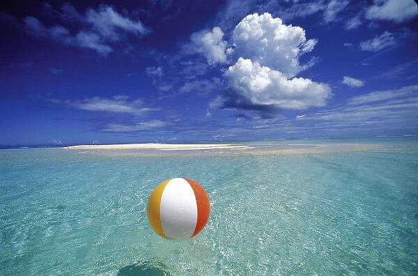 French Polynesia, Bora Bora, Calm Ocean With Beach Ball Foreground Patch Of Sand Background Blue Sky Clouds