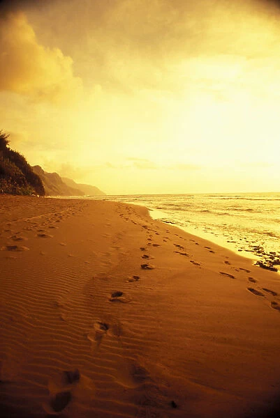 Hawaii, Kauai, Na Pali Coast, Beach At Sunset With Footprints In Sand, Golden Sky And Water