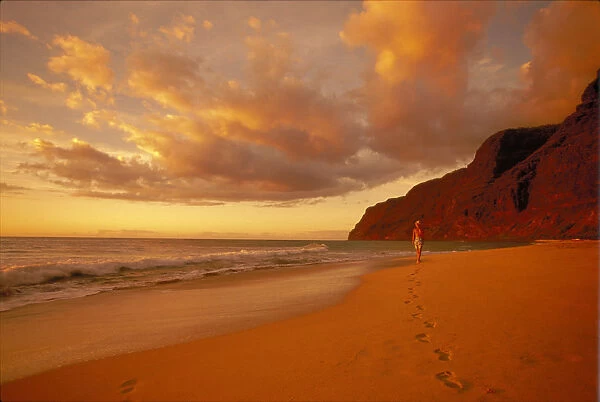 Hawaii, Kauai, Polihale Beach At Sunset Golden Light, Woman Walk Shoreline Footprints Puffy Clouds
