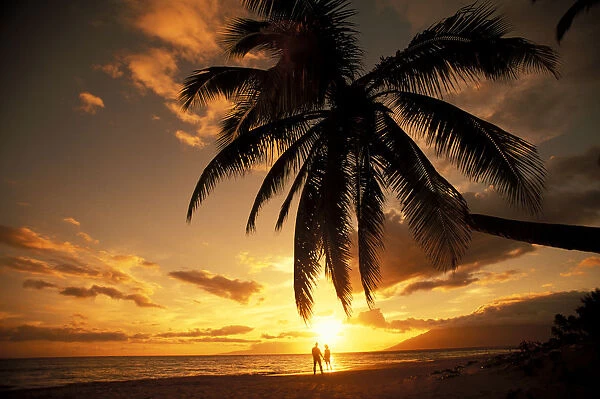 Hawaii, Maui, Kihei, Kamaole One, Distant View Of Couple Walking Along Beach At Sunset