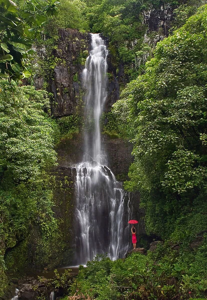 Hawaii, Maui, Kipahulu, Hana Coast, Woman Stands With Umbrella At Wailua Falls Surrounded By Foliage