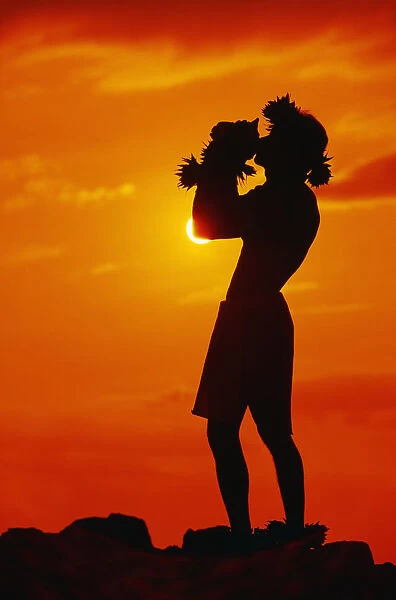 Hawaii, Maui, Napili, Silhouette Of Man Blowing Conch Shell At Sunset, Fiery Orange Sky