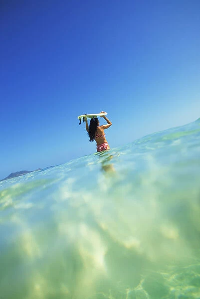 Hawaii, Oahu, Lanikai Beach, Over  /  Under View Of Woman Holding Surfboard On Head
