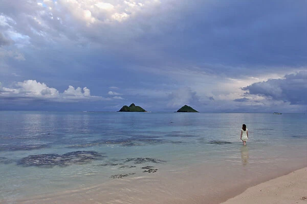 Hawaii, Oahu, Lanikai, A Woman Wades In The Water At The Beach At Dusk