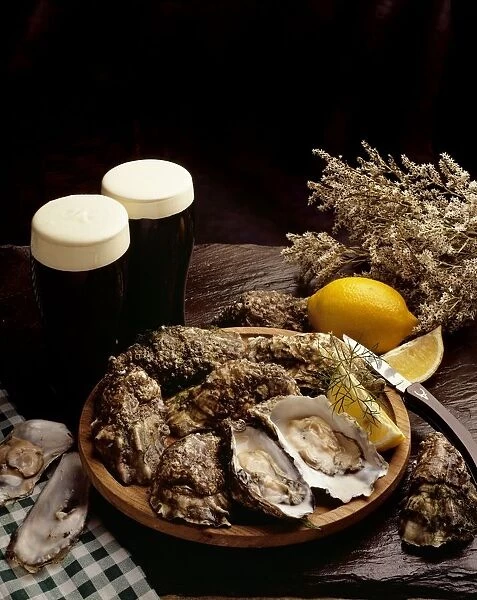 High Angle View Of A Platter Of Oysters With Glasses Of Beer On A Table