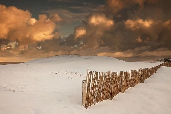 Illuminated Clouds Glowing Over A Snow Covered Field And Fence; South Shields, Tyne And Wear, England