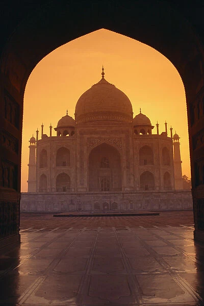 India, Agra, View Of Taj Mahal Through Archway Of Adjacent Building, Orange Sunset Sky