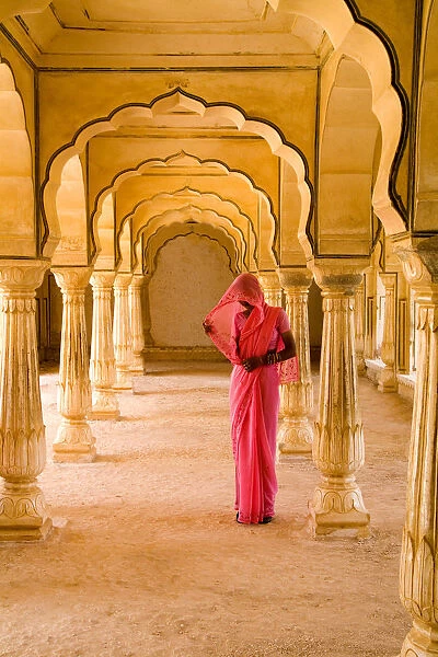 India, Rajasthan, Jaipur, Amber Fort Temple, Woman In Bright Pink Sari Stands Beneath Arches