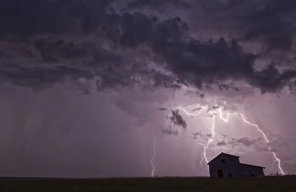 Lightning Strikes Over The Prairies As It Approaches An Old Abandoned Farm House; Val Marie, Saskatchewan, Canada