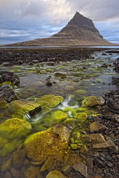 The Mountain Kirkjufell Rises Above The Ocean Near Town Of Grundarfjorour, Snaefellsnes Peninsula; Iceland