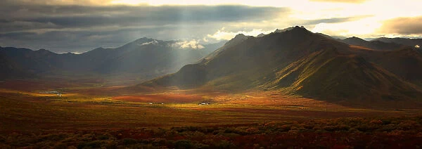 Panoramic Image Of The Cloudy Range With Shafts Of Sunlight Hitting The Fall Colours Of The Dempster Highway, Yukon