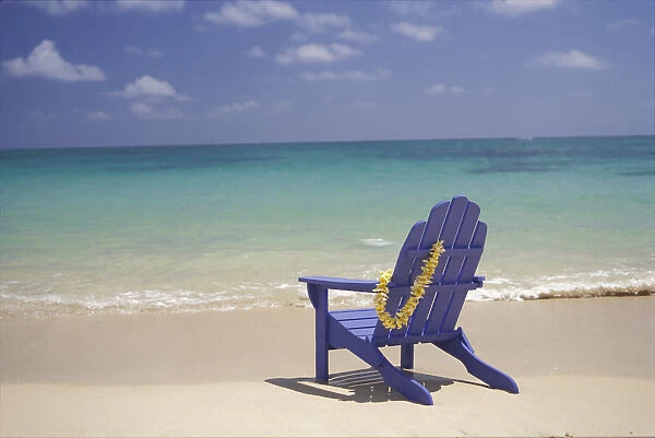 Plumeria Lei Hanging Over Blue Beach Chair Along Shoreline