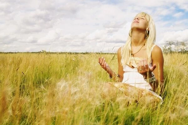 Portrait Of Woman Praying In Field