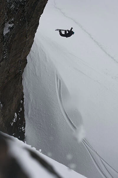Professional Snowboarder Making An Extreme Jump Of A Vertical Wall Near Ushuaia, Patagonia, Argentina, South America