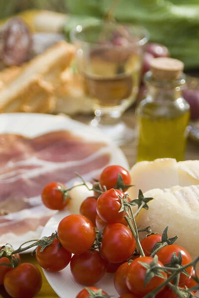 Prosciutto Ham, Cheese, Tomatoes, White Wine And Other Ingredients For Picnic, Tuscany, Italy