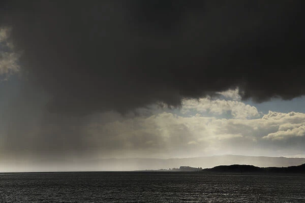 Rain Falling From Ominous Dark Clouds Over The Water; Otter Ferry, Scotland
