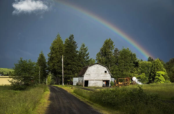 A Rainbow Appears Over An Old Barn; Astoria, Oregon, United States Of America
