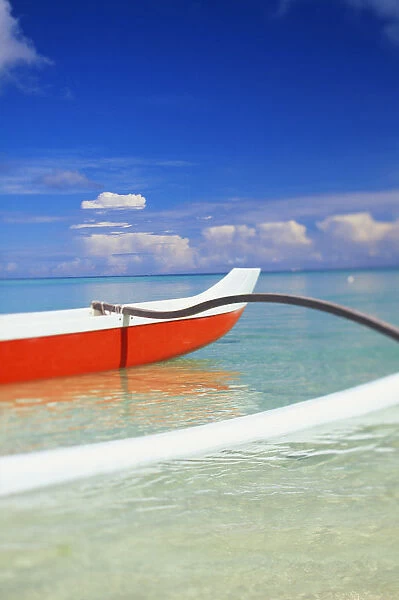 Red And White Outrigger Canoe Floating On Calm Turquoise Water