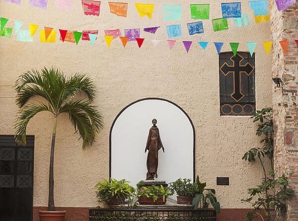 A sculpture of san francisco de assisi is sheltered by the church of our lady of guadalupe; Puerto vallarta mexico